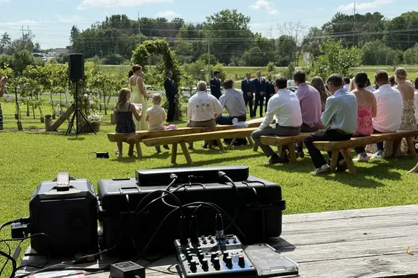 Wedding ceremony sound system setup with speakers and microphones at a vineyard
