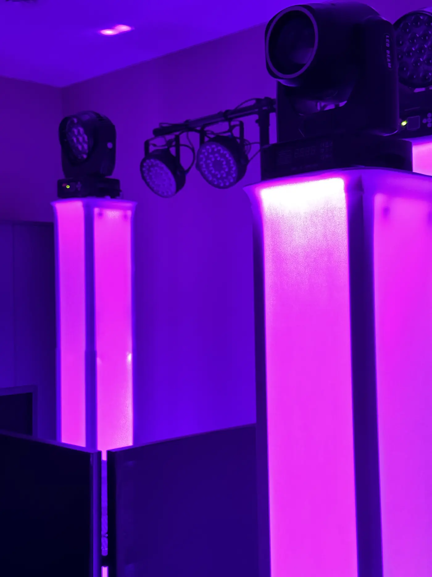 Moving heads, LED PAR cans, and illuminated column totems in saturated magenta at a Minnesota event